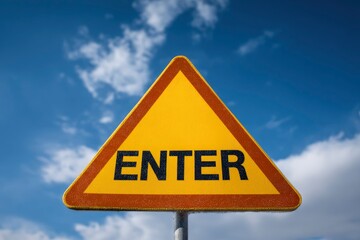 A triangular yellow sign with ENTER written in black The sign has an orange border and stands against a blue sky with clouds