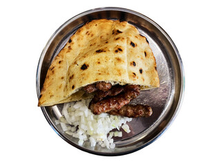 Delicious flatbread filled with spiced meat served on a silver plate with chopped onions