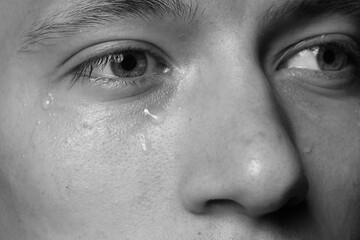 Fototapeta premium Closeup view of sad man crying. Black and white effect