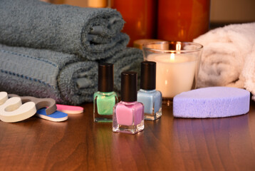 Multi colored nail polish bottles on a wooden background stock photo images. Manicure pedicure tools still life photo. Nail polish bottles, towel and nail file on a wooden background