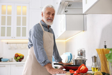 Elderly man cooking dish on cooktop in kitchen