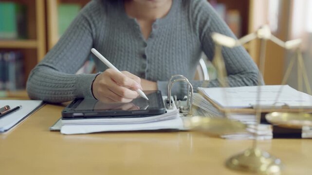 Confident young asian woman studying law with gavel and scales of justice, determined to succeed in legal career.