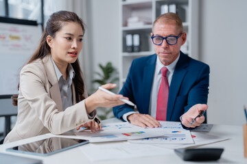 Business partners collaborating in an office while analyzing financial reports and charts, discussing strategies, planning growth, and making important decisions