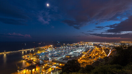 Seaport and loading docks at the port with cranes and multi-colored cargo containers day to night timelapse
