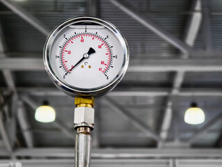 Pressure gauge measures force in industrial setting showcasing equipment functionality and design clarity
