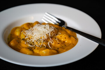 Gnocchi in pumpkin sauce with Parmesan cheese