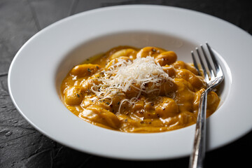 Gnocchi in pumpkin sauce with Parmesan cheese