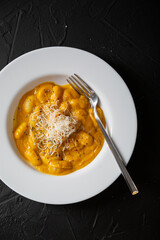 Gnocchi in pumpkin sauce with Parmesan cheese