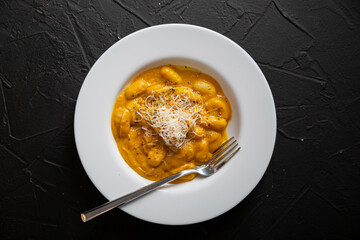 Gnocchi in pumpkin sauce with Parmesan cheese