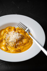 Gnocchi in pumpkin sauce with Parmesan cheese