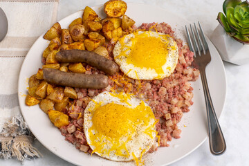 fried eggs  on corn beef hash amdsausages