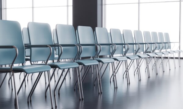 A row of blue chairs with metal arms faces a bright window in a modern room - Powered by Adobe