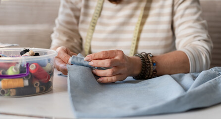 Woman Seamstress Matching Thread To Fabric Color