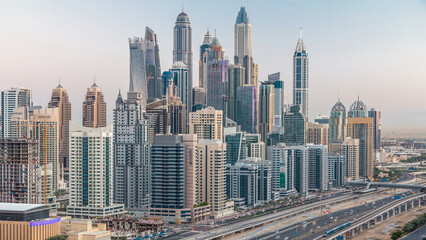 Dubai Marina skyscrapers aerial top view before sunrise from JLT in Dubai night to day timelapse, UAE.