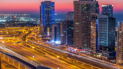 Dubai marina with traffic on sheikh zayed road panorama day to night timelapse lights turn on.