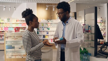 Obraz premium African American doctor pharmacist medical recommendation advice dosage pills pharmacy customer buy medicine vitamins health care medication drugstore woman man consulting help disease symptom therapy