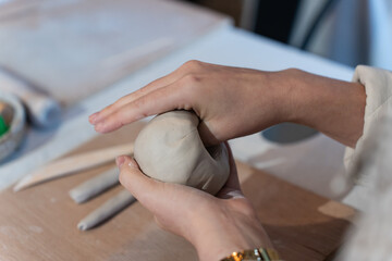 Woman working on clay at a pottery hand building class