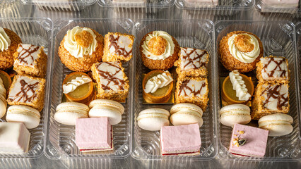 Assorted dessert boxes with macarons, mousse cakes, and pastries