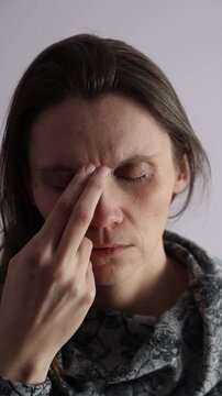 Female tapping EFT technique eyebrow point on a face. Vertical video.