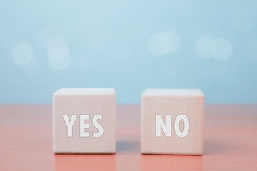 Wooden cubes with the words YES and NO on pastel background, representing choice, decision making, agreement or disagreement concept for business, psychology, or communication themes.