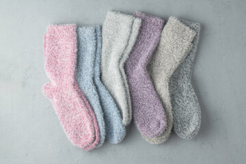 Set of fluffy pastel socks made from cashmere and mink blend, arranged on a light background, symbolizes warmth, care and cozy comfort.