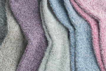Close-up of soft fluffy pastel socks shows delicate texture and gentle colors, evoking warmth,...