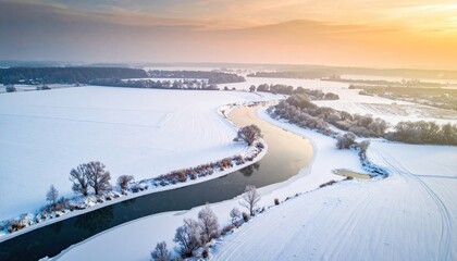 Aerial View of Winding River through Snow Covered Landscape at Winter Sunrise, Majestic Scenery and Horizon Glowing with Warm Orange
