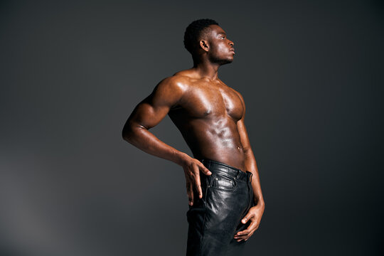 Muscular African American man showcases strength and confidence in studio setting