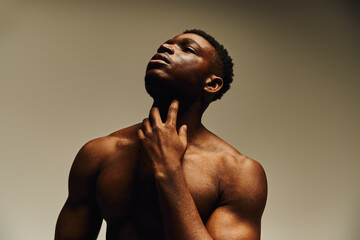 Strong and confident african american man showcasing his physique in a studio setting