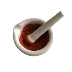 Grinding of natural pigments in a ceramic mortar. Cadmium red. Isolated on a white background