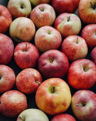 Red apples in the market. Fruit background - red n orange texture of apples stacked in a few layers.
