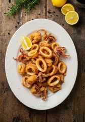 Crispy fried squid on old wood dinning table. Top down view.