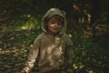 Little boy enjoys a walk in the forest and has fun