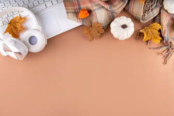 Cozy autumn background with laptop, fall leaves, pumpkins and plaid. Autumn office work, education...