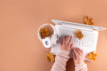 Cozy autumn background with laptop, fall leaves, pumpkins and plaid. Autumn office work, education...