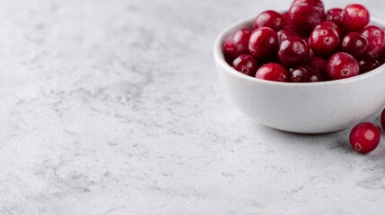 Blueberries in a white bowl with blueberry jam on a gray and white backdrop, showcasing a minimalist and clean aesthetic with ample negative space