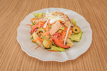 A salad composition where cherry tomatoes explode with color against red onion and curly   lettuce, tossed with golden olive oil.