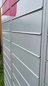 Close-up of a hand placing a parcel into a parcel locker and closing the locker door. Natural lighting conveys delivery, drop-off and last-mile logistics.