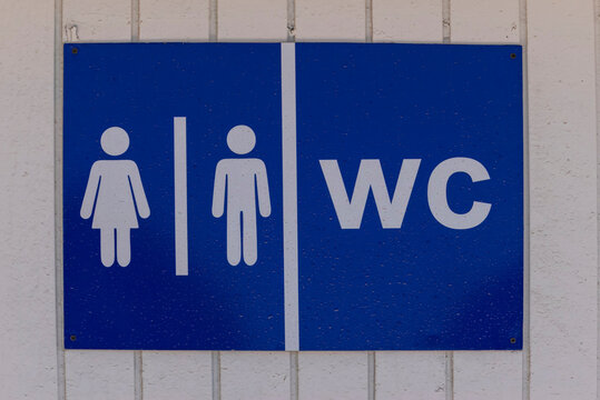 Blue Toilet Sign with Male and Female Icons on White Panel