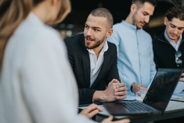 Group of colleagues working together outdoors, engaging in a collaborative business meeting