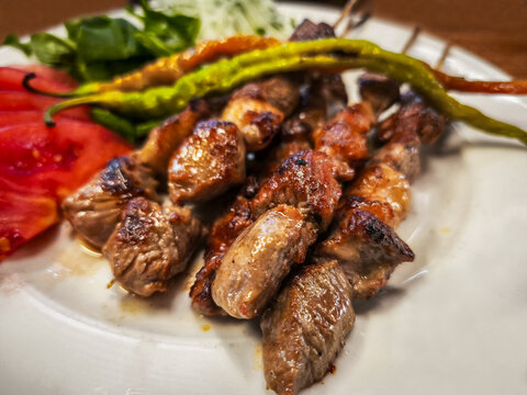 Turkish style meal. Lamb skewers on a white plate.