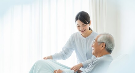 Asian woman gently adjusts blanket with warm smile for elderly man