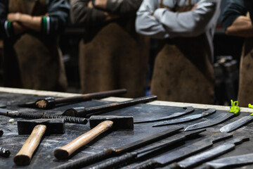 Group of people waiting to work in iron forging workshop