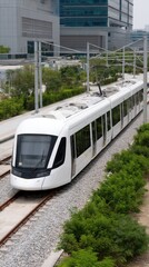 A sleek tram moves gracefully down a path surrounded by trees and modern architecture under a clear sky, showcasing urban transport
