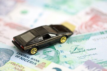 Nigerian naira currency money bills and toy car. The concept of car ownership