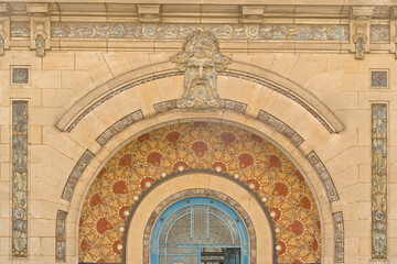 Obraz premium Art deco decoration with mosaic abstract patterns and sculpted face of the entrance of the Saint Georges swimming pool of Rennes, France 