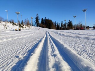 Obraz premium Cross-country skiing area in Kubalonka near Wisla, Poland. Ski resort snow routes with lighting infrastructure for night skiing.