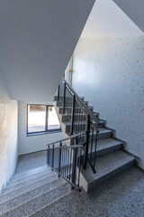 Modern stair case between floors. Stairs with metallic rail in modern building