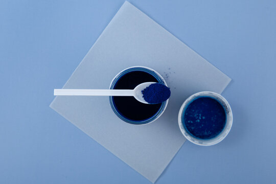 Brilliant blue FCF dye powder or Xylene Blue VSG in measuring spoon, top view. Food additive, E133. Triarylmethane dye. Organic pigment used as colorant in food, cosmetic and medicine
