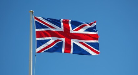 Union Jack flag flies proudly against a clear blue sky.